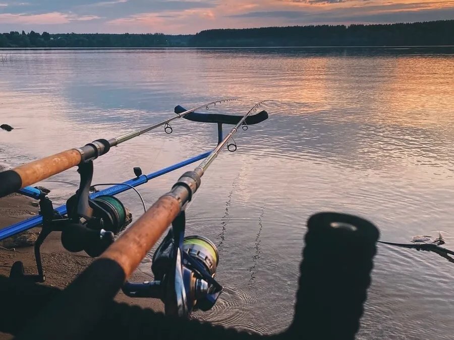 Удочки на подставке у воды на закате